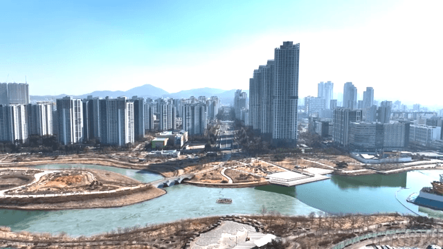 Modern city skyline with a river and park