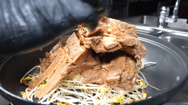 Pork neck bones for pork backbone stew piled high on top of bean sprouts