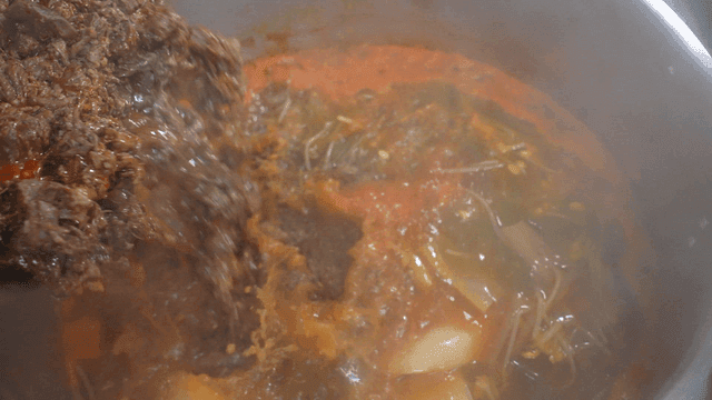 Beef added to broth in large pot with beef stew