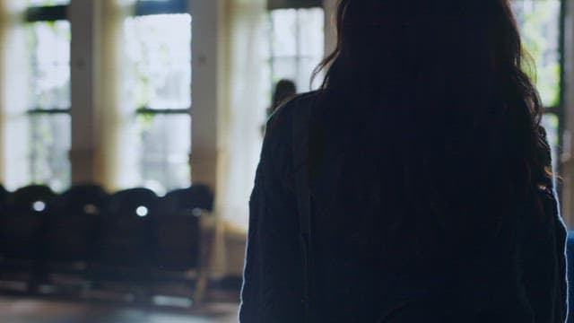 Two women standing quietly in a sunlit room