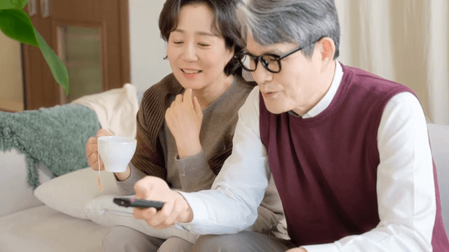 차를 마시며 TV를 보는 노부부