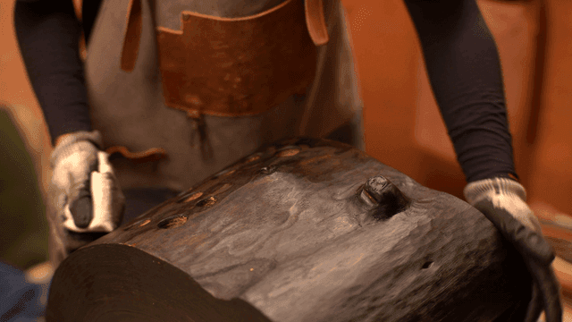 목조 조각을 수건으로 다듬는 장인