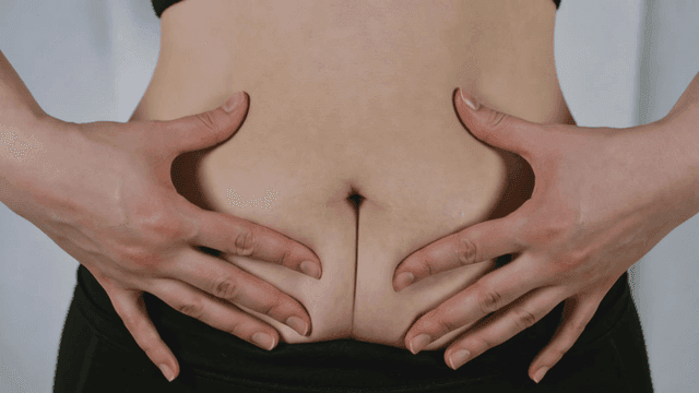 Hand grabbing belly fat