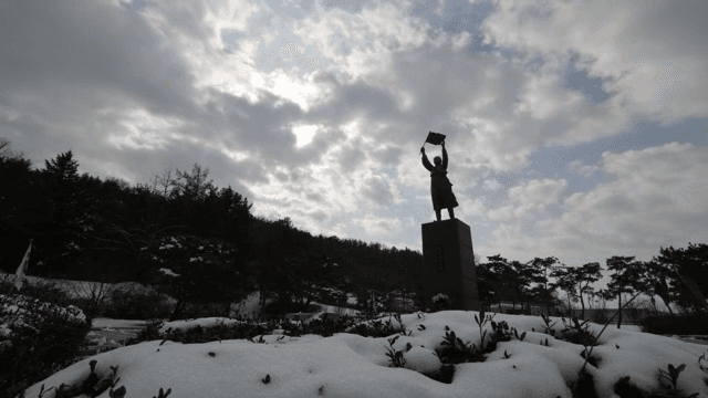 눈 덮인 풍경의 동상 위로 흐르는 구름