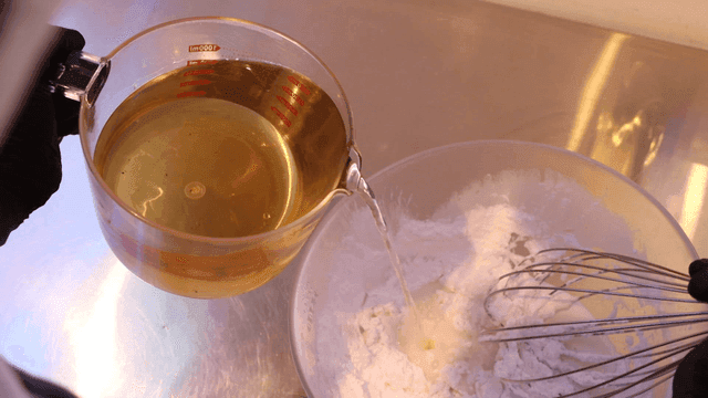 밀가루가 든 그릇에 액체를 붓는 장면