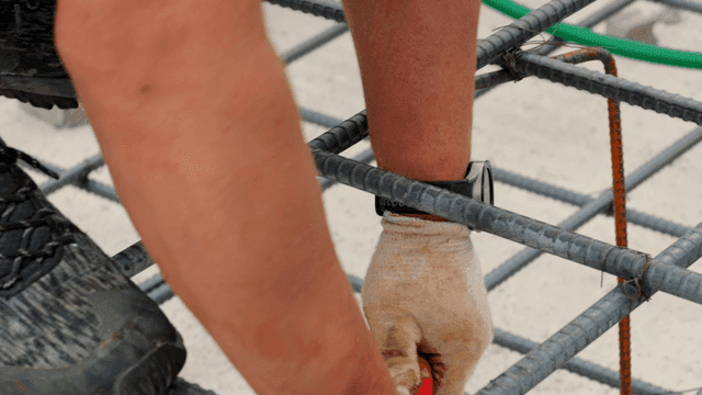 Worker handling rebar at a construction site