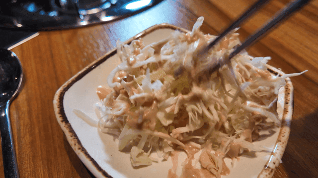 Salad drizzled with mayonnaise dressing that mixes well with chopsticks