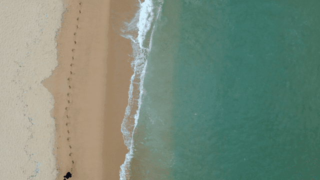 Person walking on sandy beach