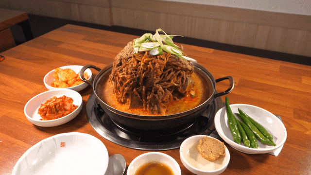 테이블 위에 고구마순이 올라간 감자탕 한 상