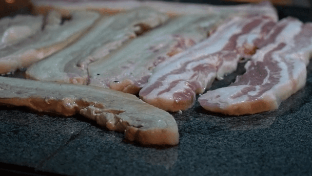 뜨거운 돌판 위에 삼겹살 굽기