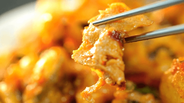 젓가락으로 집은 익힌 고기 조각