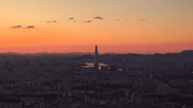 Cityscape with tall towers rising under sunset sky