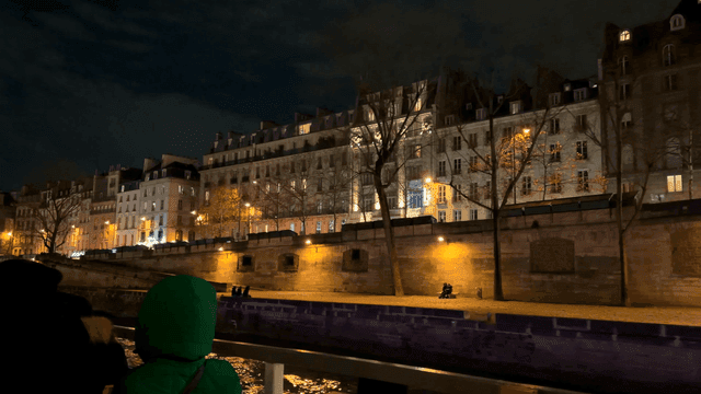 Night view of European city with lit-up buildings seen from ship