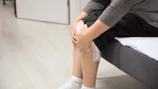 무릎에 패치를 붙인 사람