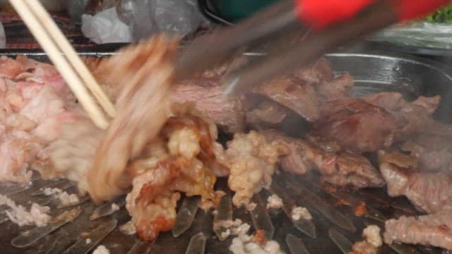 불판 위에서 젓가락으로 구워지는 차돌박이