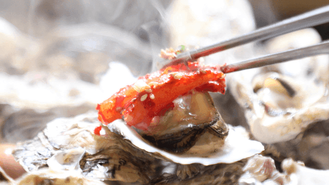 Steamed oysters topped with spicy kimchi
