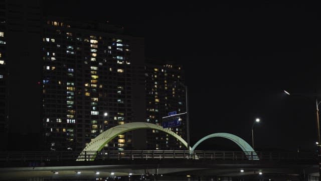 Illuminated Bridge and Apartment Buildings at Night