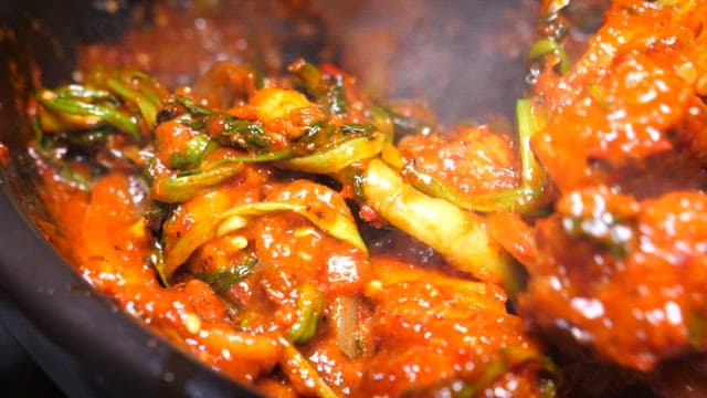 푸른 양파와 참깨가 얹어진 매운 쭈꾸미 볶음