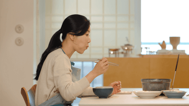 Woman eating at dining table at home