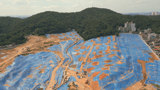 Construction site with blue tarps and hills