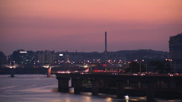 Twilight Cityscape and Traffic on Bridge