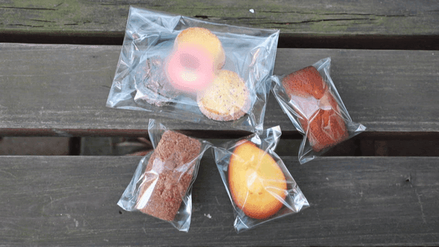 Various packaged desserts placed on wooden bench