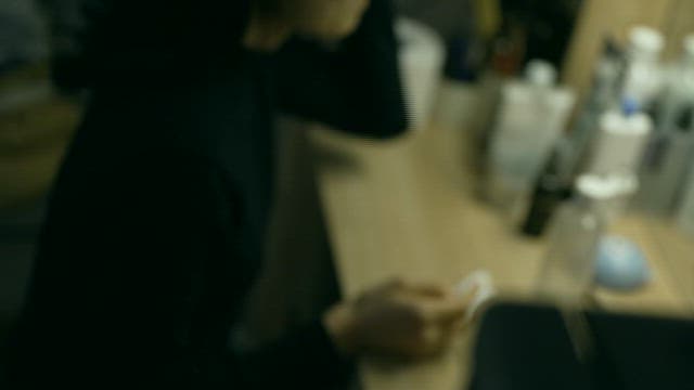 화장품이 많은 화장대에 앉아 거울을 보는 여자