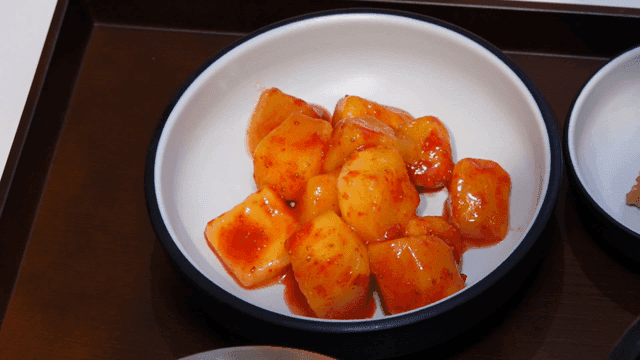 깍두기 모양의 딸기 가루를 뿌린 망고 무침