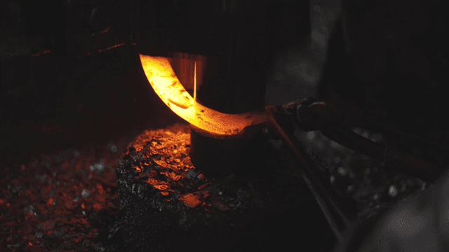 작업장에서 기계로 단조되는 뜨거운 금속