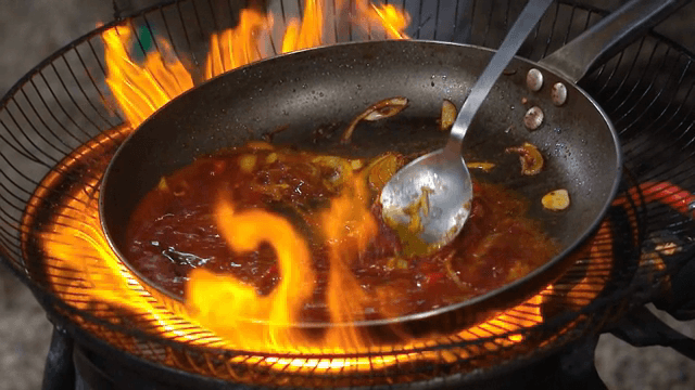불 위에서 소스와 볶은 채소를 요리하는 모습