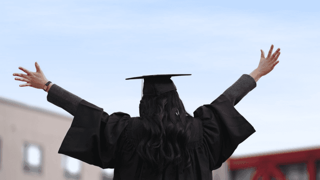 Back view of graduates raising their arms in celebration