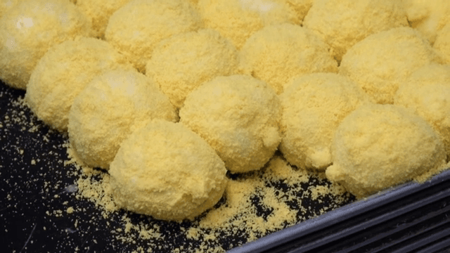 Yellow rice cake being prepared on a tray