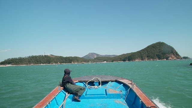 Fishing boat sailing the blue sea on a clear day