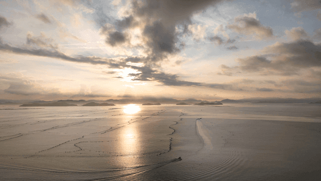 Calm sea with distant island visible at sunset