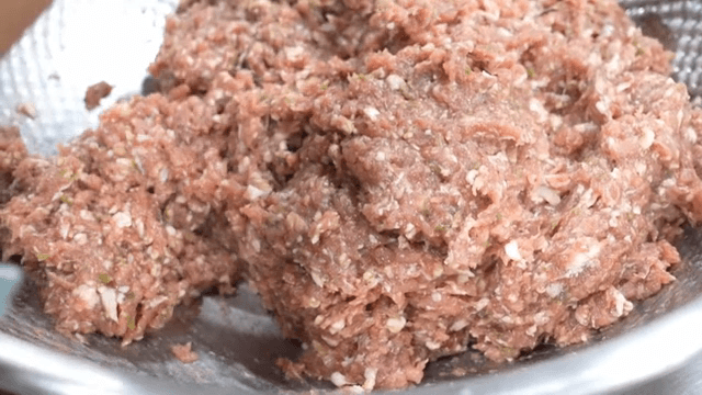금속그릇에서 다진고기를 섞는 모습