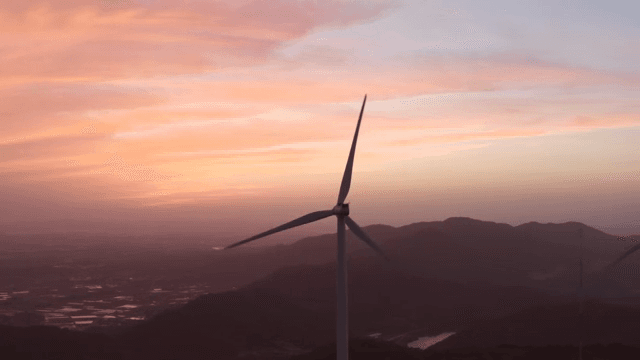 핑크빛으로 물들은 하늘 아래 산악 지역의 풍력 터빈