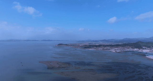A vast coastal landscape with clear skies
