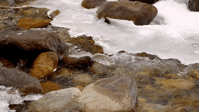 얼음이 낀 바위 사이로 흐르는 작은 시냇물