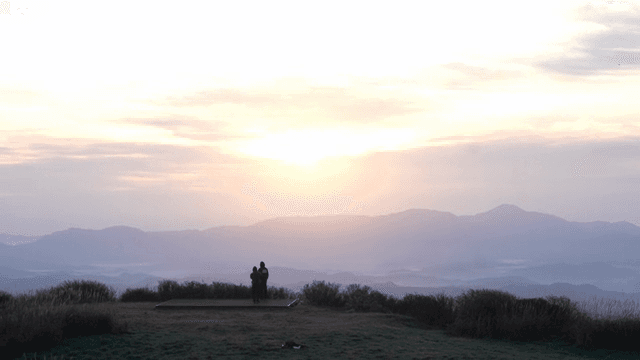 산에서 일출을 즐기는 커플
