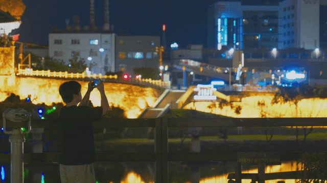 밤 전통 성곽을 휴대폰으로 찍는 남성