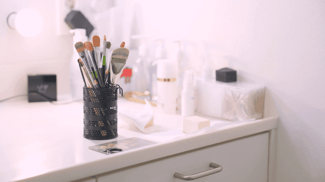 Makeup brushes and cosmetics on a counter