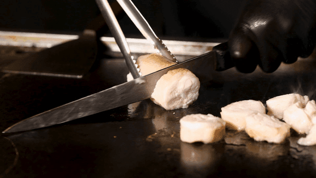 Beef intestines being sliced ​​on hot grill
