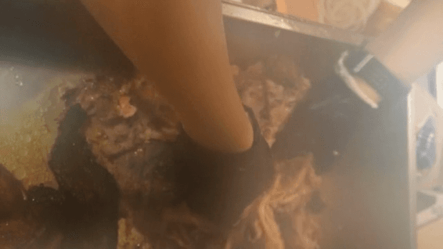 큰 용기에서 고기를 섞는 손