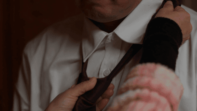 Adjusting a tie on a white shirt