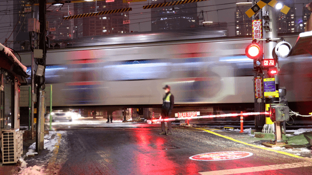 Train passing through night city intersection