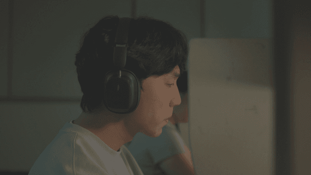 Person wearing headphones in a dark reading room