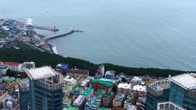 헬기 선착장이 있는 건물들이 보이는 해안 도시