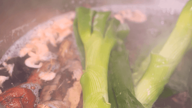 Pot with boiling broth ingredients