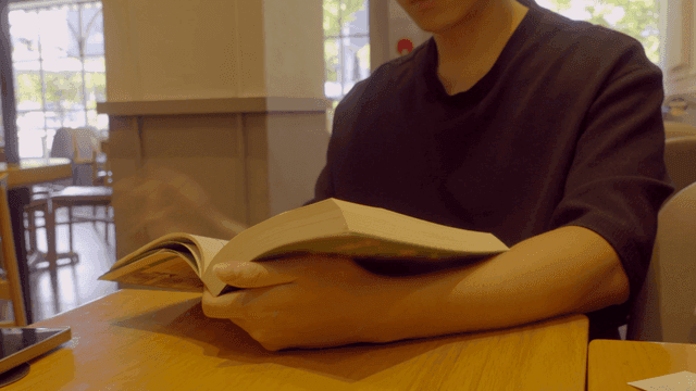 Person reading a book in a cafe