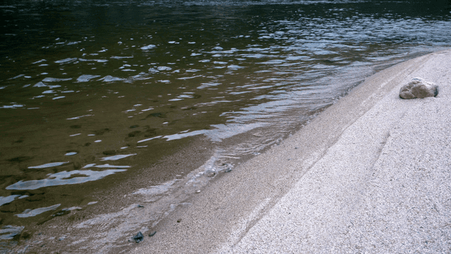 고요한 강가의 모래사장과 바위